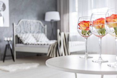 Yatak odasında bardaklarda gül