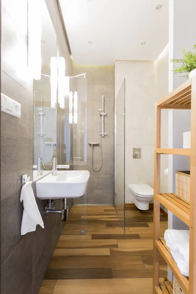Narrow loft bathroom with wooden floor — Stock Photo, Image
