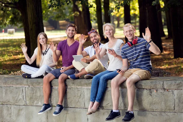 Amici felici seduti insieme — Foto Stock