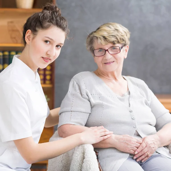 Pflegekraft und positive Seniorin — Stockfoto