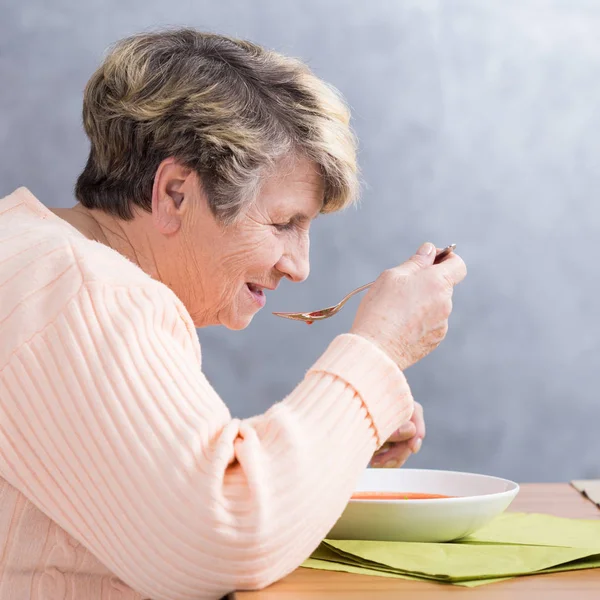 Senior Kvinna äta en soppa — Stockfoto