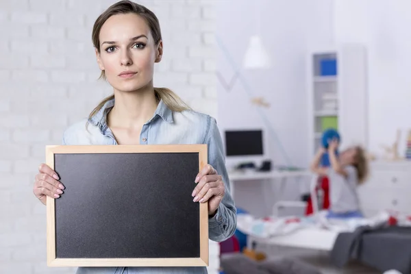 Mujer sosteniendo pizarra pequeña — Foto de Stock