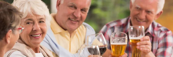 Elderly friends toasting a drink