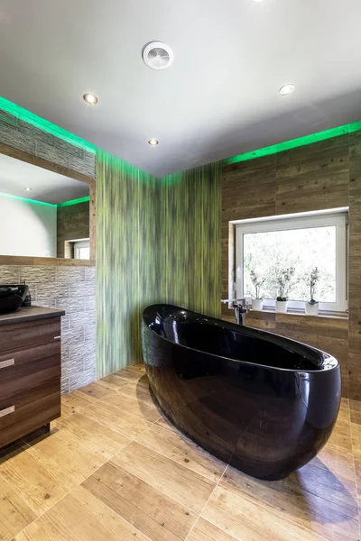 Травертина ванная комната с черной ванной — стоковое фото