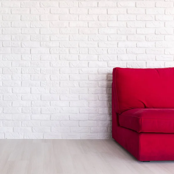 Κόκκινο καναπέ σε απλό λευκό εσωτερικό — Φωτογραφία Αρχείου