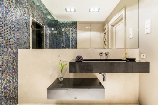 Ванная комната с минималистской раковиной и мозаичной стеной — стоковое фото