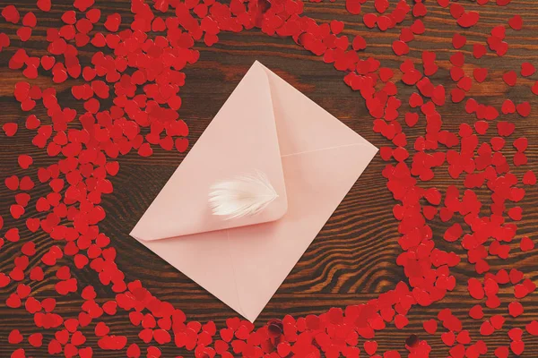 Roze enevelope en rode harten — Stockfoto
