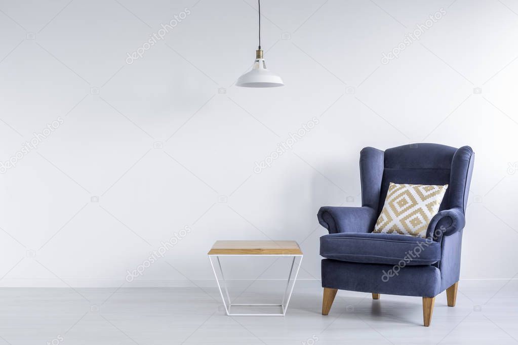 Ascetic room with blue armchair