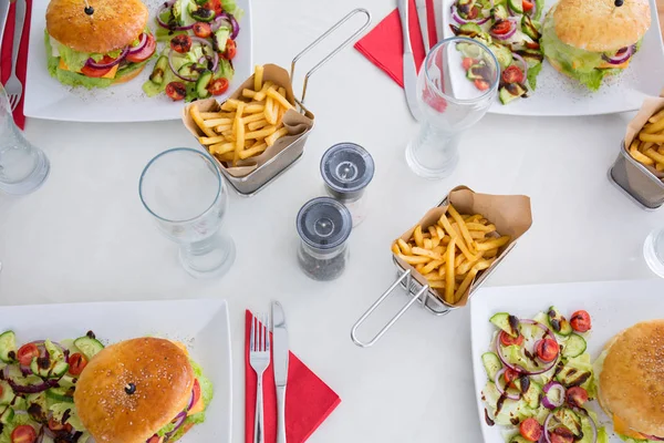 Deliciosos hambúrgueres à mesa — Fotografia de Stock