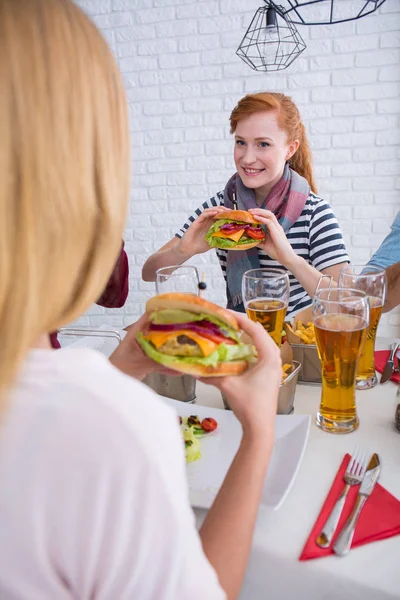 Girls eating burgers — Stock Photo, Image