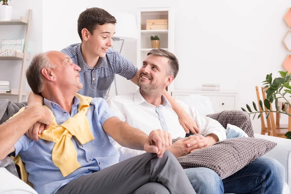 Rapaz abraçando sua família — Fotografia de Stock