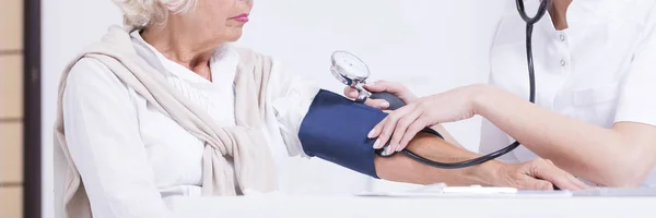 Médico midiendo la presión arterial del paciente —  Fotos de Stock