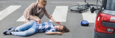 Bilinçsiz bir bisikletçi yardımcı olmak çalışan bir kadına