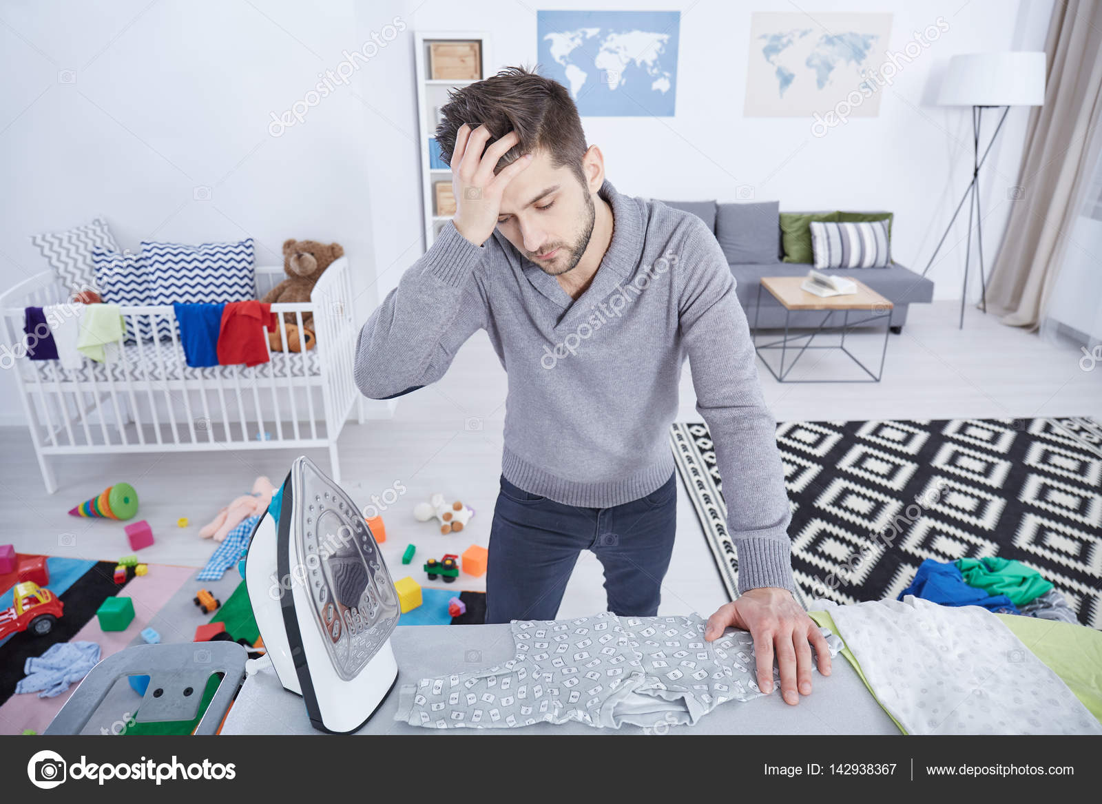 Tired man ironing baby clothes — Stock Photo © photographee.eu 142938367