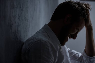 Adam elini başının üstüne tutuyor