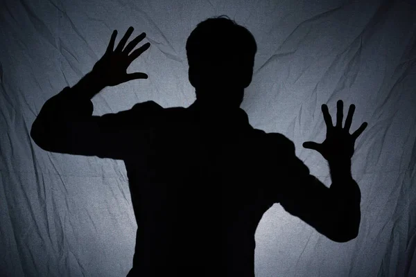 Shadow of man behind dark fabric — Stock Photo, Image