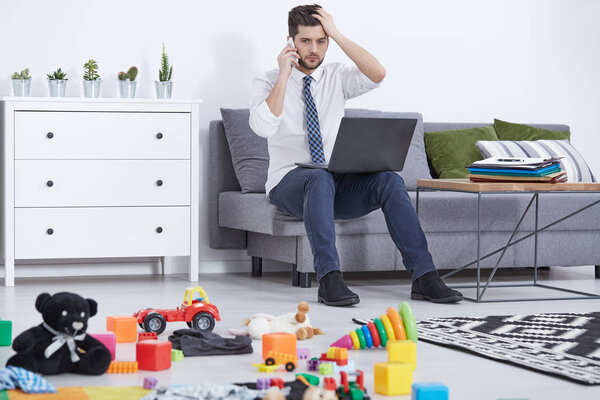 Ошеломленный отец разговаривает по телефону
