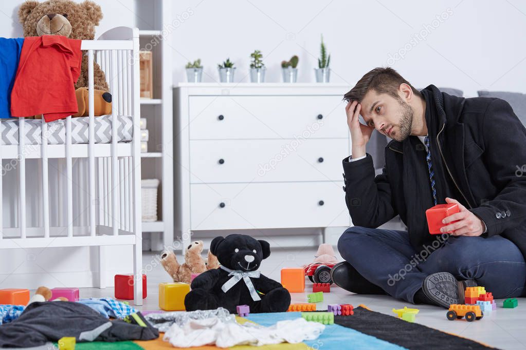 Tired father sitting on floor