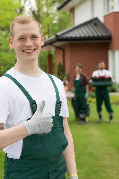 Улыбающийся садовник стоит с поднятым большим пальцем — стоковое фото