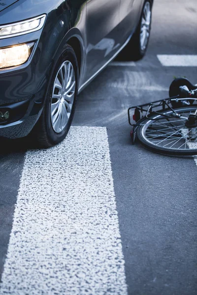 Sepeda tergeletak di samping mobil di penyeberangan pejalan kaki — Stok Foto