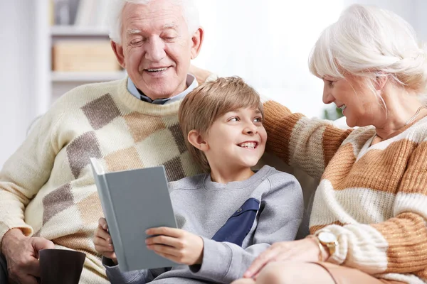 Abuelos leyendo libro con nieto — Foto de Stock