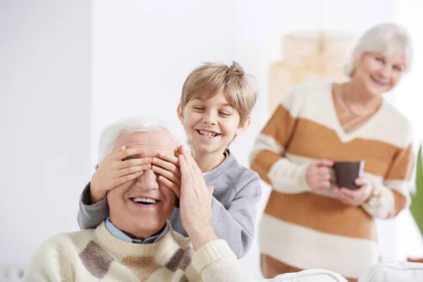 Pojke som täcker sin farfars ögon — Stockfoto