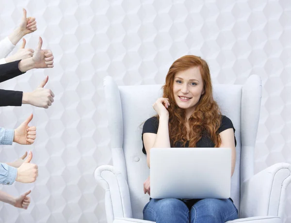 Vrouw in fauteuil met laptop — Stockfoto