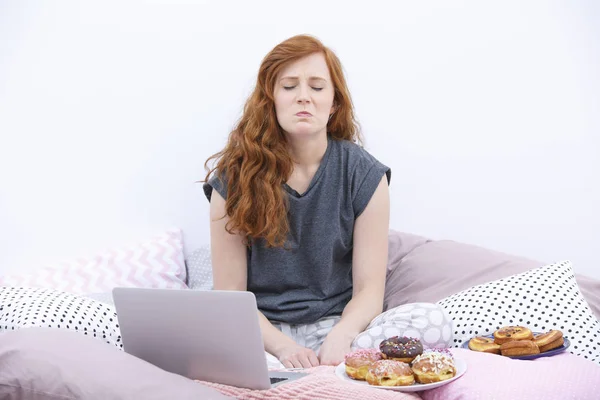 Schmollende Frau sitzt auf dem Bett — Stockfoto