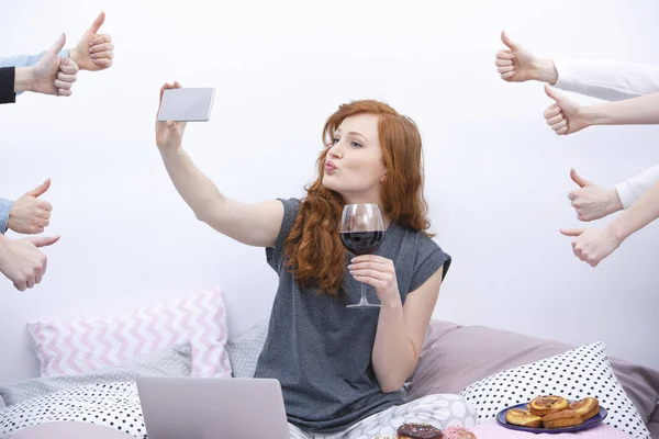 Woman taking selfie on bed — Stock Photo, Image