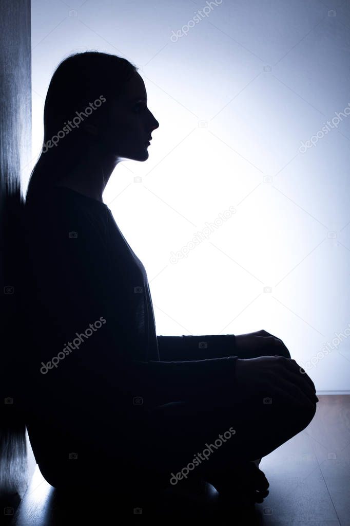 Girl sitting back to wall