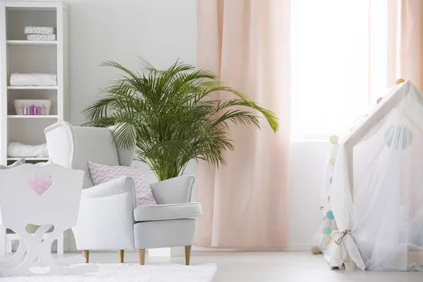 Armchair and crib in baby room — Stock Photo, Image