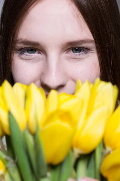 Mujer joven y montón de tulipanes — Foto de Stock