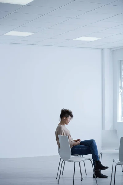 Женщина сидит в светлой комнате — стоковое фото
