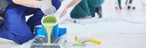 Man pouring paint into tray — Stock Photo, Image