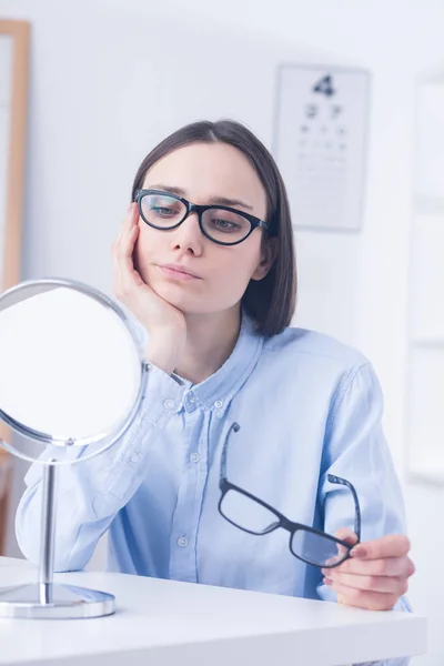 Niezdecydowany klient wybierając okulary — Zdjęcie stockowe