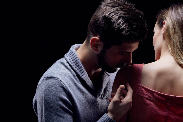Man kissing his girlfriend's shoulder