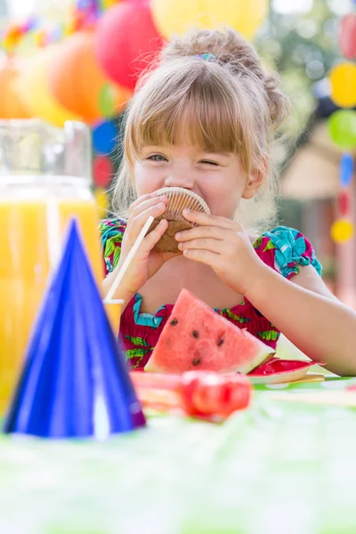 Chica comiendo magdalena durante la fiesta —  Fotos de Stock