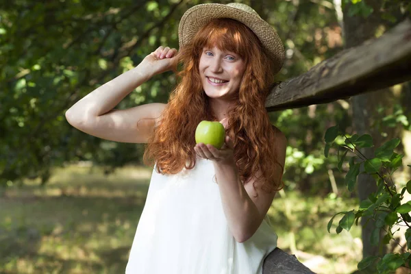 Mujer con cabello de jengibre sosteniendo una manzana —  Fotos de Stock