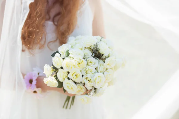 Sposa che tiene un mazzo di rose bianche — Foto Stock