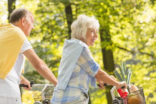 Mature woman cycling in park — Stock Photo, Image