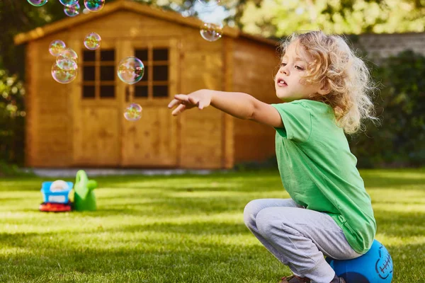 Liten pojke leker i trädgården — Stockfoto