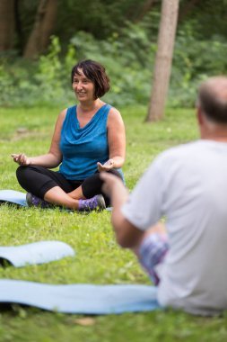 Yoga sınıfındaki bir park sırasında üst düzey insanlar