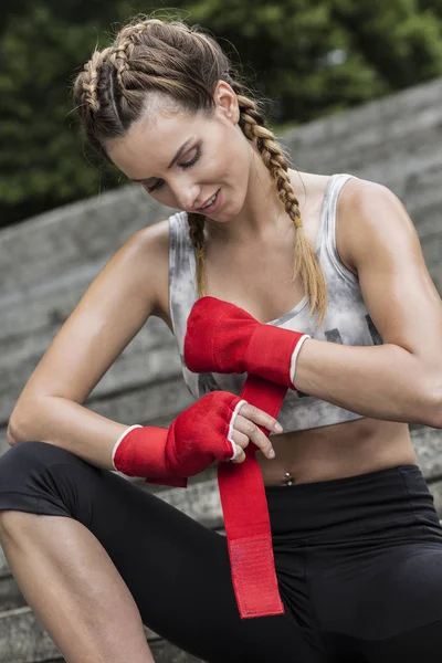Mujer en forma envolviendo sus guantes de entrenamiento —  Fotos de Stock