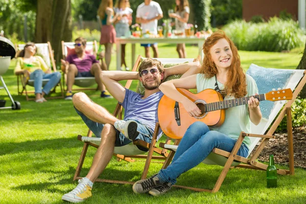 Mujer tocando la guitarra en jardín —  Fotos de Stock