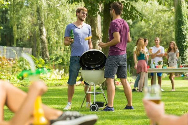 Two men standing beside grill — Stock Photo, Image