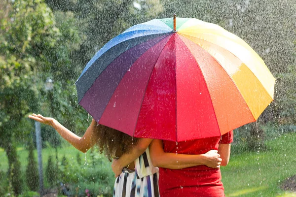 Paar onder de paraplu van de regenboog — Stockfoto