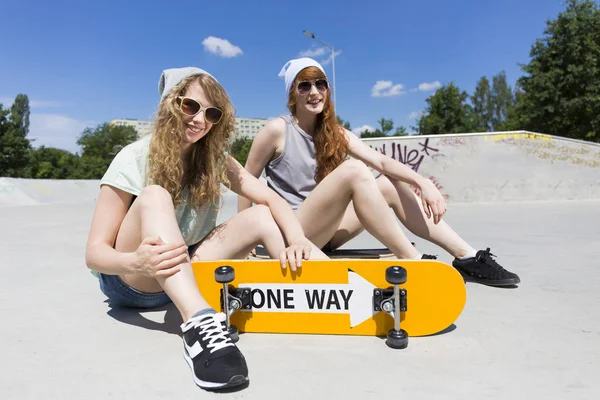 Děvčata sedí na zpočátků s skateboard — Stock fotografie