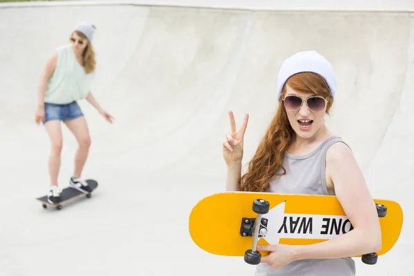 Ragazza in piedi con lo skateboard — Foto Stock