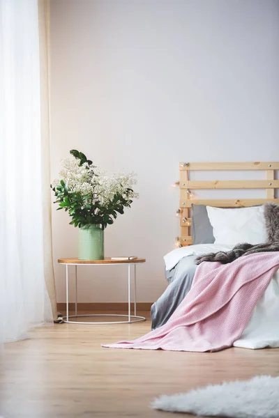 Bed en nachtkastje met bloemen — Stockfoto