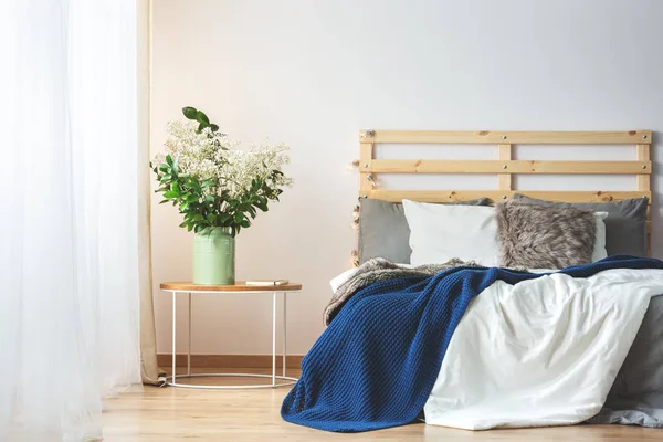 Bed en bloemen in slaapkamer — Stockfoto